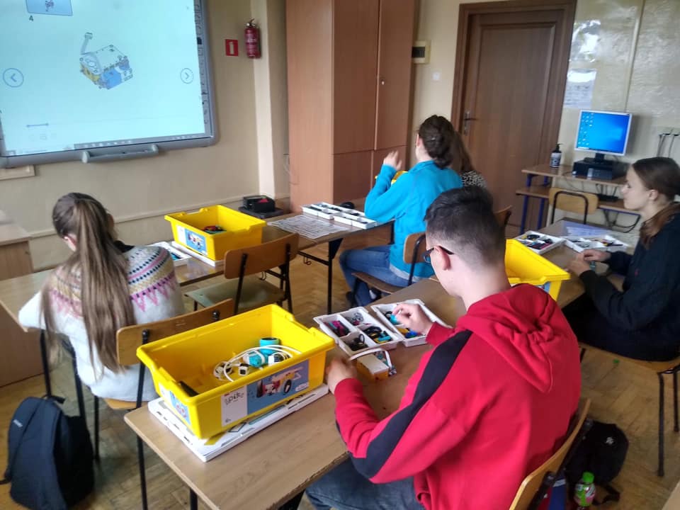 Uczniowie w klasie budują pojazdy z klacków Lego.