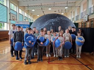 Uczniowie stoją przed mobilnym planetarium
