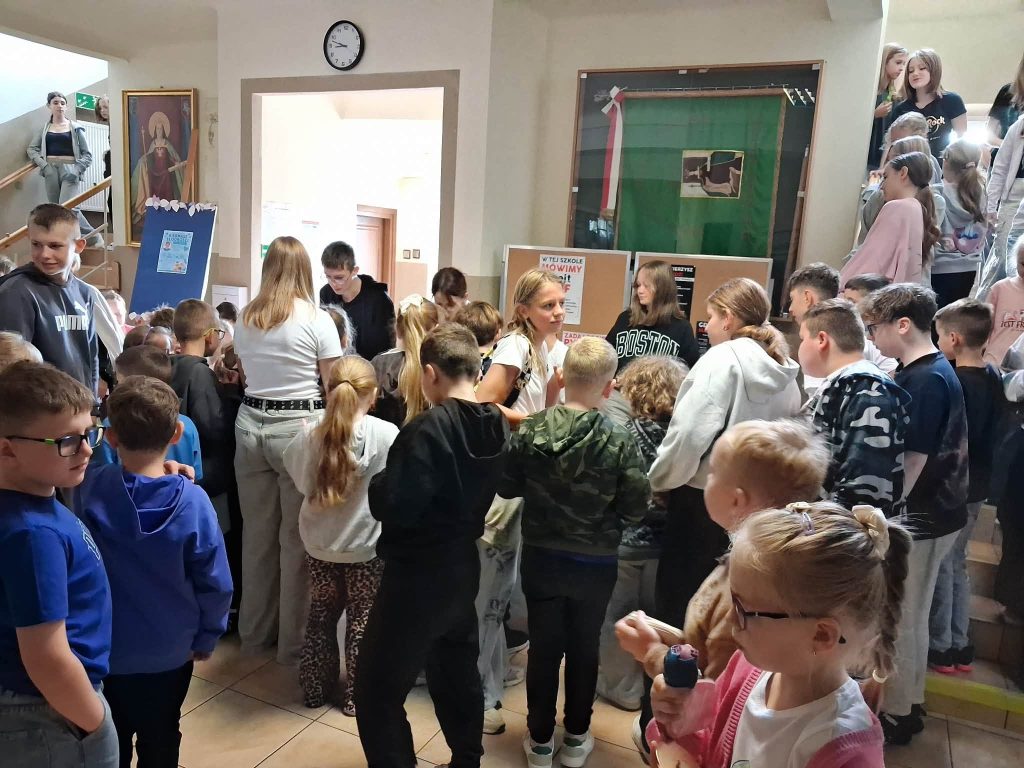 Uczniowie na korytarzu szkolnym uczestniczą w kiermaszu słodkości